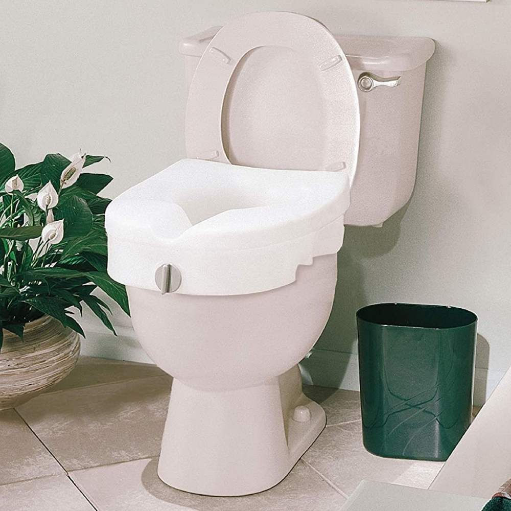 A bathroom with a raised toilet seat and a clamp on bath rail fitted